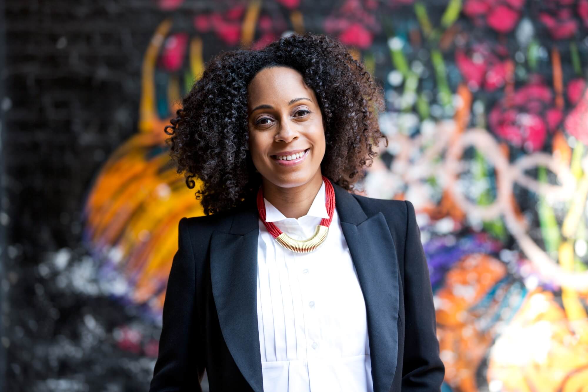 Remi Harris standing in front of a wall of graffiti